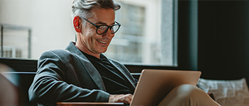 Business man sitting on couch and working on laptop