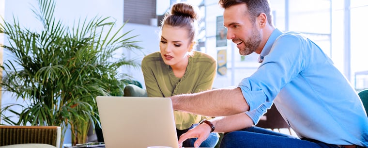 Two young professionals meeting and looking at laptop