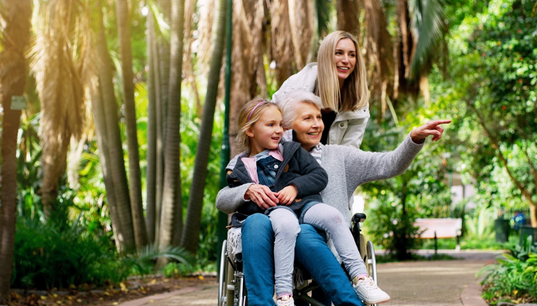 Elderly woman, wheelchair and child with lady in nature for retirement