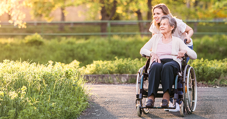 women pushing an older women in a wheelchair