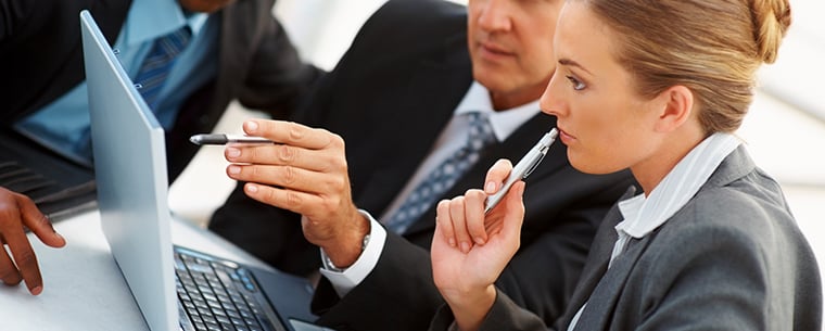 Business people in a meeting looking at a laptop