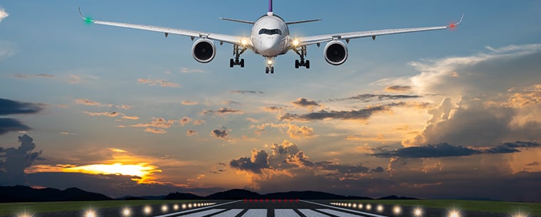 Airplane taking off at sunset