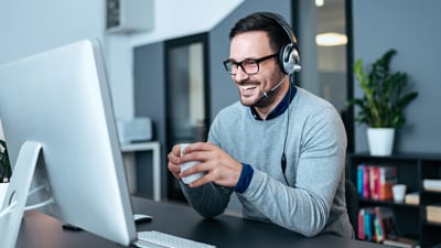Guy drinking coffee working at computer
