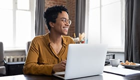 woman smiling sitting at a laptop