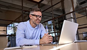 Happy mature business man at laptop